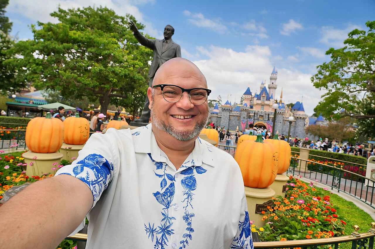 Carlos smiling at Disneyland with Sleeping Beauty Castle in the background